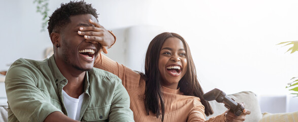 Two friends share a joyful moment while playing video games together. The atmosphere is lighthearted and playful, filled with laughter and friendly competition.