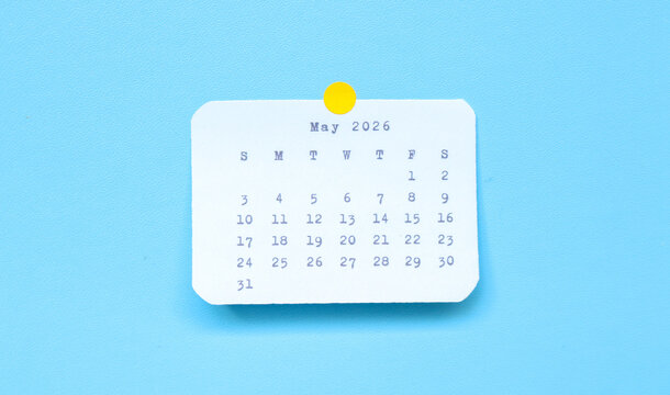 A paper sticker showing may 2026 placed on a blue background. A may 2026 sticker attached to a blue background. Minimal and clean calendar concept.