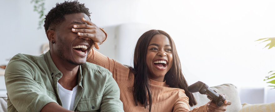 Two friends share a joyful moment while playing video games together. The atmosphere is lighthearted and playful, filled with laughter and friendly competition.