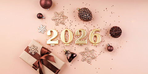 2026 golden number candles with gift baubles pinecone wooden snowflakes and confetti on pastel surface flat lay top view copy space