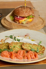 Sophisticated food display showcasing sesame bun burger with assorted fresh accompaniments