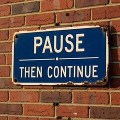 An old, slightly weathered blue sign, attached to a red brick wall, displays the white text 'Pause, Then Continue', creating a thoughtful visual prompt with a sense of temporal reflection and aged
