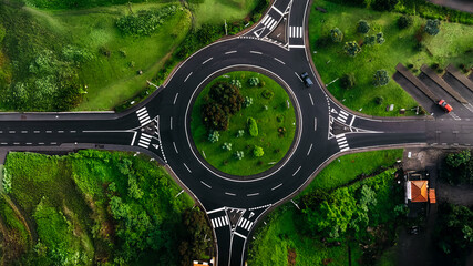 Aerial view of a circular intersection surrounded by lush greenery and vibrant landscaping, showcasing modern urban infrastructure and nature's harmony in travel destinations