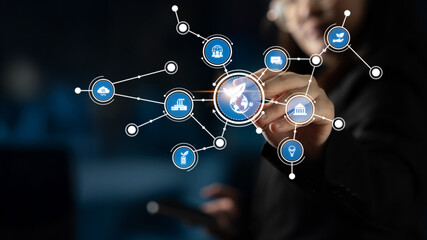 A businesswoman engages with a digital interface, manipulating icons representing global connections. This image captures the essence of modern technology and communication. Tessel