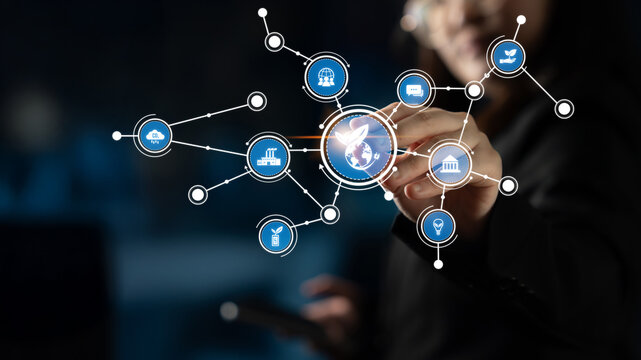 A businesswoman engages with a digital interface, manipulating icons representing global connections. This image captures the essence of modern technology and communication. Tessel