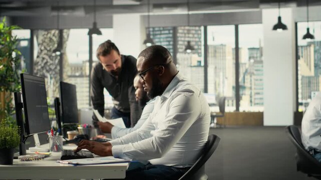 Employees team discussing business intel and performance in modern space. Multinational company staff members reviewing reports, forecasts and diagrams to align strategy. Camera B.