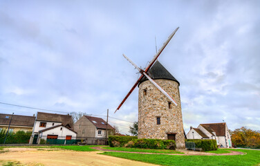 The historic Moulin de Montfermeil or Sempin Windmill in France. The stone structure with wooden...