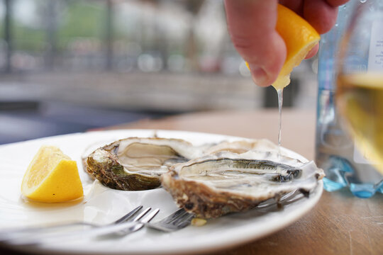 Squeezing lemon on the oyster.