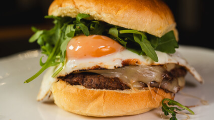 Nutritious burger with egg, fresh arugula (rocket), and lean beef on a whole wheat bun. High-protein, balanced meal for fitness and clean eating lifestyles.