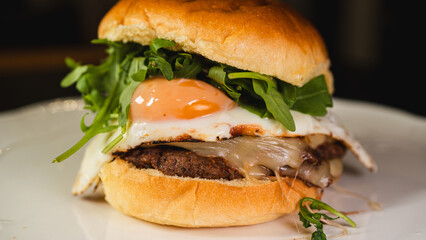 Nutritious burger with egg, fresh arugula (rocket), and lean beef on a whole wheat bun. High-protein, balanced meal for fitness and clean eating lifestyles.