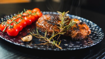 Whole rare rump steak served on a beautiful plate, topped with garlic and rosemary. Steam rising from the juicy meat with a golden crust. Ready to eat, gourmet presentation.