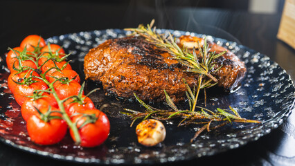 Whole rare rump steak served on a beautiful plate, topped with garlic and rosemary. Steam rising from the juicy meat with a golden crust. Ready to eat, gourmet presentation.
