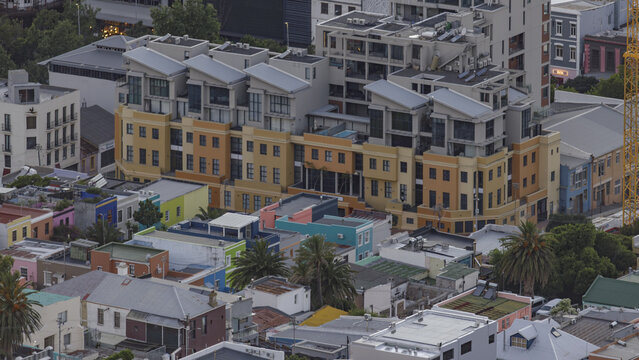 View of vibrant hues dance across the facades of tightly packed buildings, a tapestry of urban life under a soft sky, Cape Town, Western Cape, South Africa.