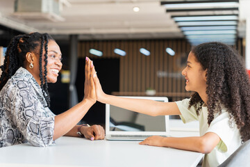 Mother and Daughter High Fiving After Successful Online Learning Session, African American Woman and Girl Celebrating Achievement While Using Laptop, Tutor and Student Giving High Five Over Computer