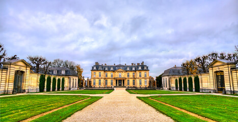 The historic Chateau de Champs-sur-Marne in the Paris region of France. The 18th-century French castle features classical architecture and symmetrical gardens under a cloudy sky