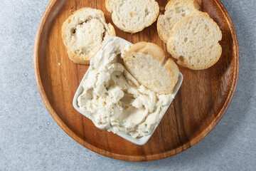 A top down view of a square bowl of dairy-free artichoke jalapeno dip.