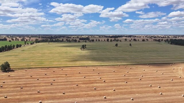Drone sweeping across stubble paddocks and baled straw
