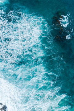 Aerial views over crashing sea waves on rocking ocean crop