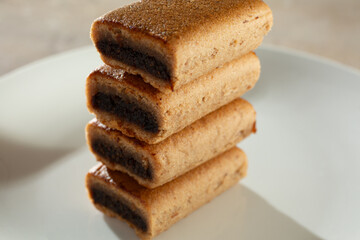 A closeup view of a stack of gluten-free fig bars, on a plate.