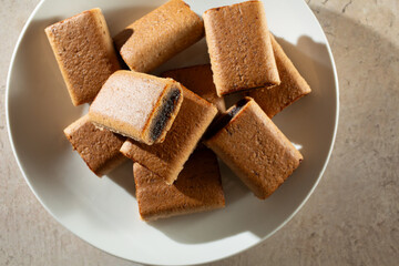 A top down view of a pile of gluten-free fig bars, on a plate.