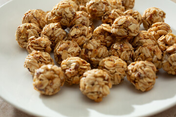 A closeup view of a pile of granola balls, on a plate.