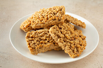 A view of a pile of honey oat granola bars, on a plate.