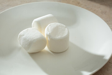 A view of a pile of marshmallows, on a plate.