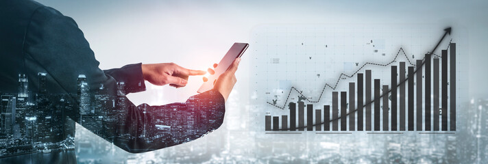 A business professional interacts with a smartphone, analyzing growth data presented in a digital graph overlay against a city skyline at night. Impute