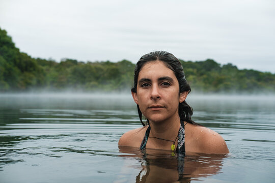 woman partially submerged in a misty lake