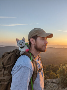 Backpacker with Cat on Mountain Peak

