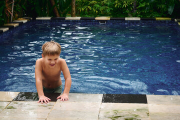 Boy enjoying a playful moment by the pool