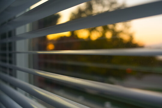 Beautiful Sunset Viewed Through Window Blinds in Urban Setting