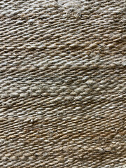 Close-up of a natural jute fiber texture with tightly woven strands in earthy beige tones, creating a rustic and organic surface ideal for backgrounds or eco-friendly design.