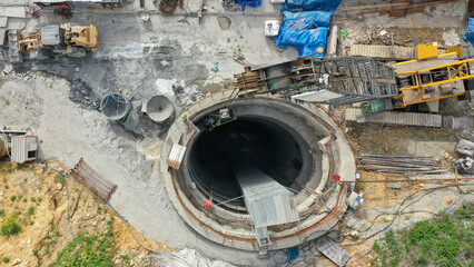 Direct top-down aerial view of a large, deep tunnel access shaft