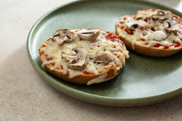 A view of dairy-free, gluten-free mushroom pizza bagels, on a plate.
