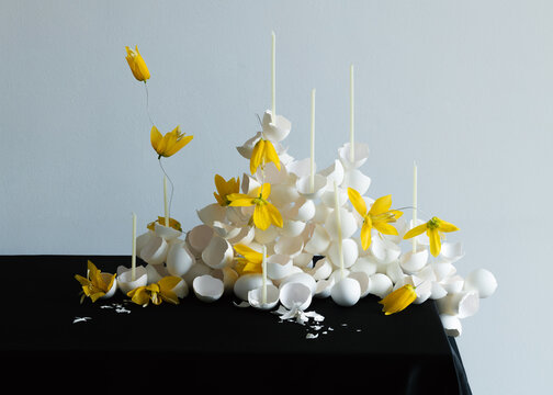 White eggs arranged with fresh flowers on a black table