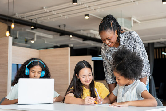 Diverse Mentor and Students Working Together in Modern Education Setting, African American Teacher Guiding Multicultural Girls in STEM Learning Project