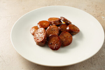 A view of a pile of sliced Spanish chorizo, on a plate.
