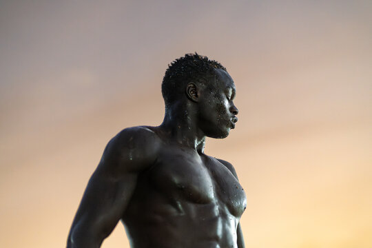 Senegalese wrestler resting after training at sunset