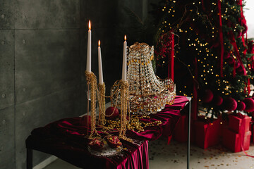 Festive holiday table with glass decorations and glowing candles.