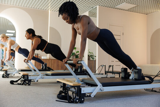 Row of multiethnic women to do plank exercise for abdominal muscles