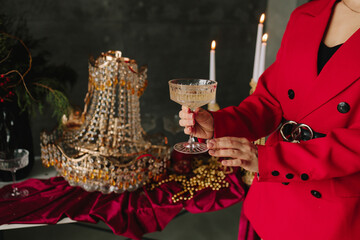 Champagne glass in hands above decorated holiday Christmas table.