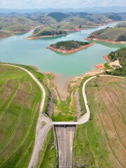 Vista do alto a seca da represa cercada de vegeta&ccedil;&atilde;o e natureza com cores vibrantes.