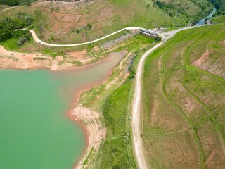 Vista do alto a seca da represa cercada de vegeta&ccedil;&atilde;o e natureza com cores vibrantes.
