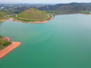 Vista do alto a seca da represa cercada de vegeta&ccedil;&atilde;o e natureza com cores vibrantes.