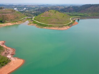 Vista do alto a seca da represa cercada de vegeta&ccedil;&atilde;o e natureza com cores vibrantes.