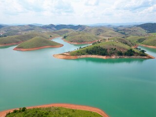 Vista do alto a seca da represa cercada de vegeta&ccedil;&atilde;o e natureza com cores vibrantes.