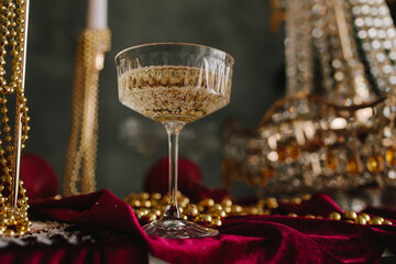 Sparkling champagne on Christmas table with festive ornaments and candles.