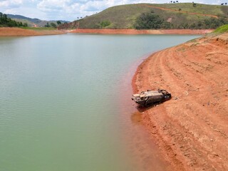 Vista do alto a seca da represa cercada de vegeta&ccedil;&atilde;o e natureza com cores vibrantes.