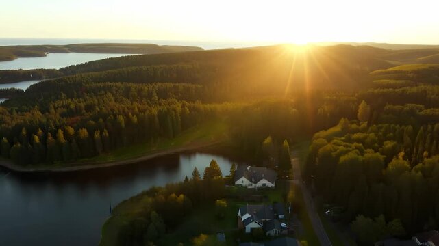 Golden sunlight bathes the lush green forest and tranquil lake, creating a serene atmosphere at dusk. The landscape unfolds with vibrant colors, inviting peaceful reflection and jo